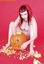 Busty redhead goth eats jack o lantern. 