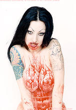 Tattooed vampire girl covers herself in blood