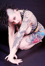 Kinky tattooed punk in leather harness