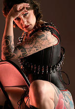 Tattooed shaved guerilla girl corset high heels