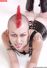 Tattooed pierced girl with mohawk in fetishwear. 