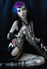 Gothic pin-up super-star in torn fishnets and purple hair