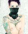 Tattooed goth girl in restrictive corset