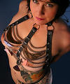 tattooed busty milf in chain and leather harness
